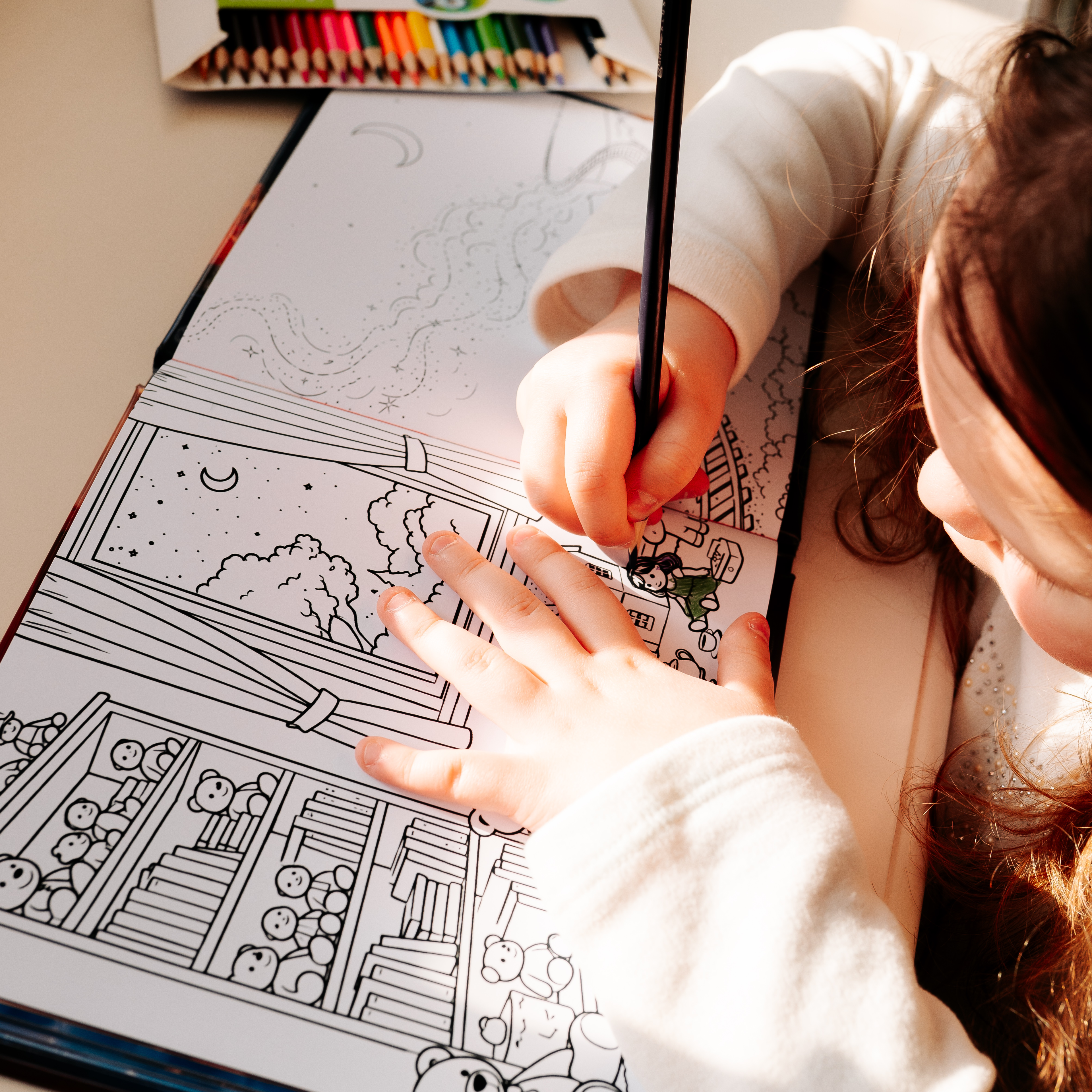 A young girl colors a black-and-white illustration in the "Child Counts to 20" activity book, using a pencil to fill in a detailed scene with a house, trees, and toys, with a set of colored pencils nearby.